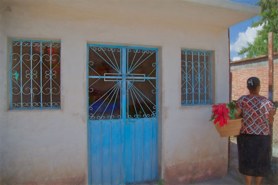 Woman with poinsettia at Mitla cemetery