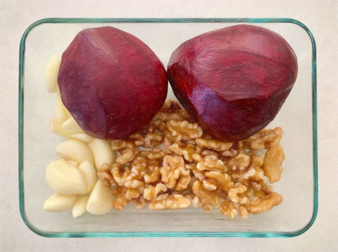 Peeled beetroot and garlic cloves with walnuts ready to roast